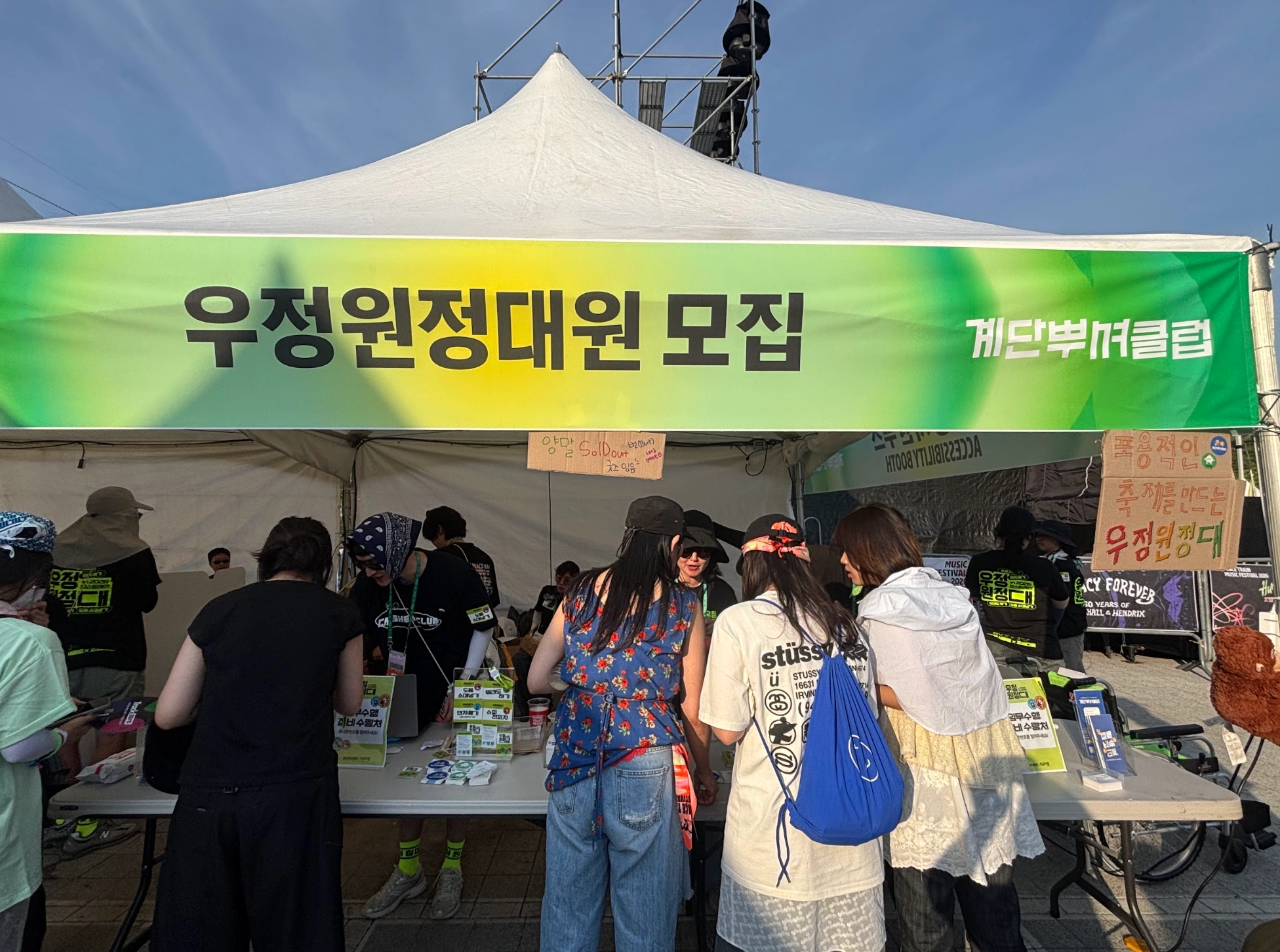 우정원정대원 모집 부스 운영 사진. 축제 관객들이 부스 테이블을 살펴보고 있다.