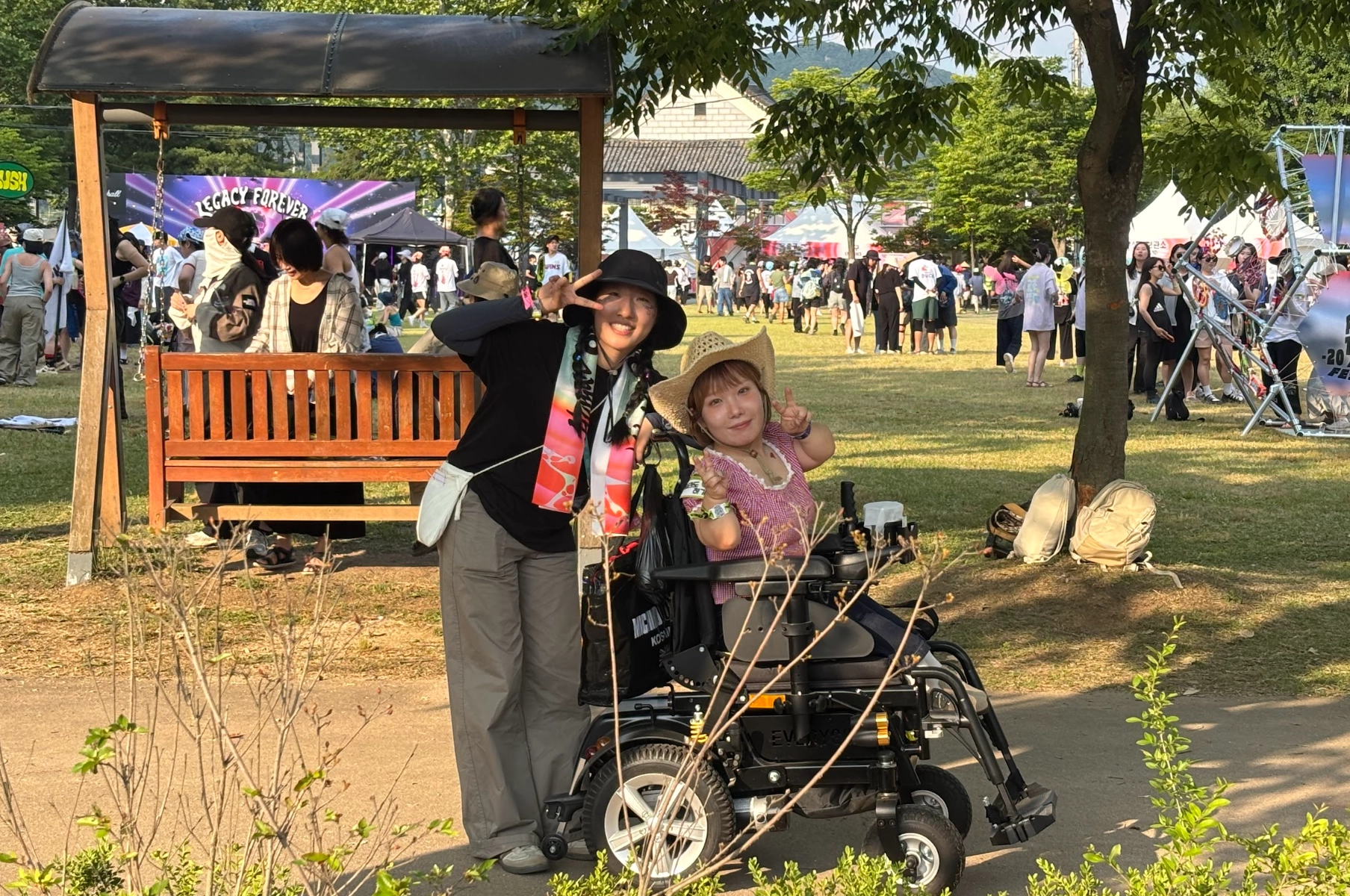 낮의 축제 현장 사진. 휠체어 이용 우정원정대원과 스태프가 함께 포즈를 취하고 있다.