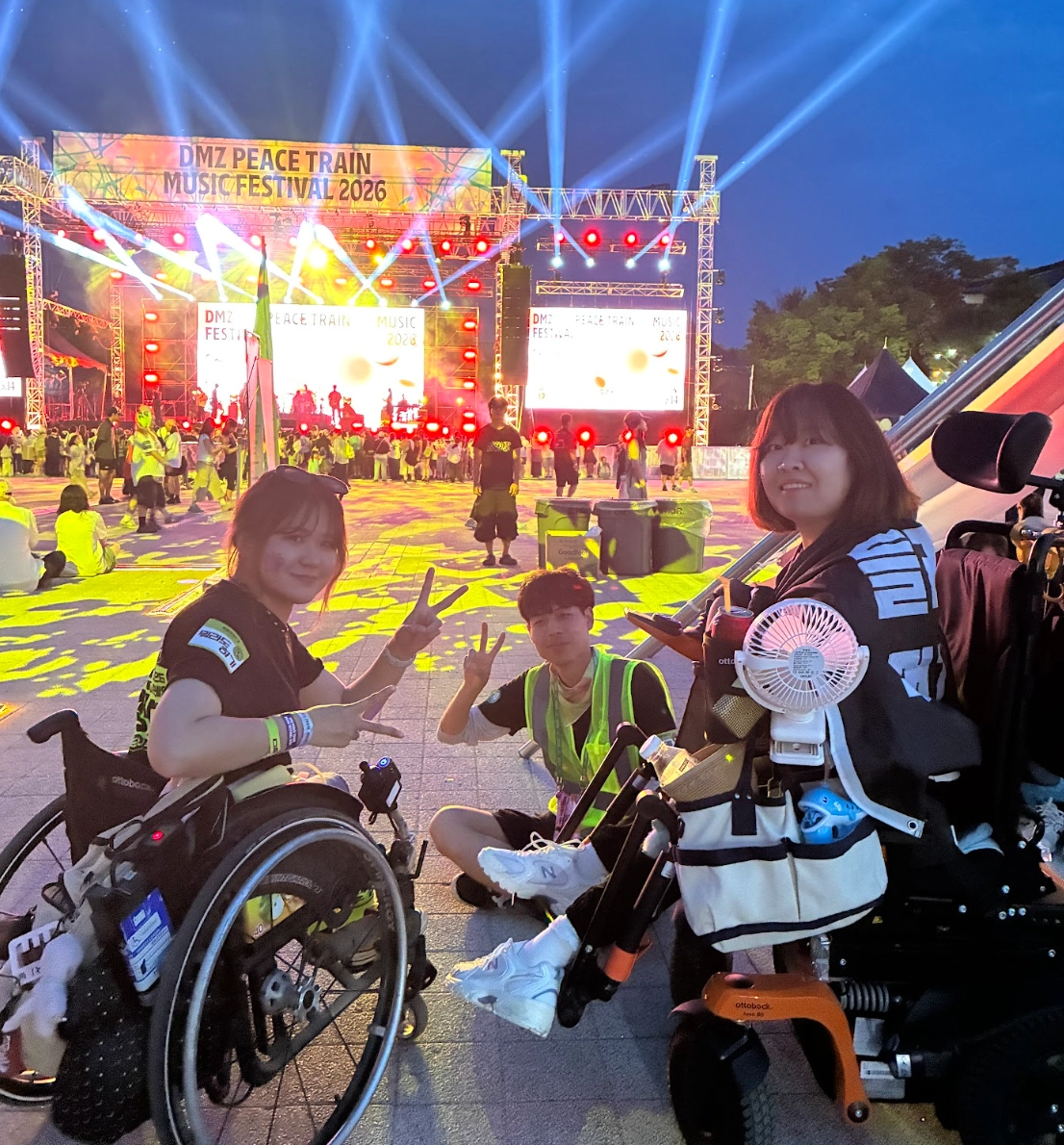 저녁의 축제 현장 사진. 컴포터블 존에서 휠체어 이용 우정원정대원 및 스태프가 함께 찍은 사진.